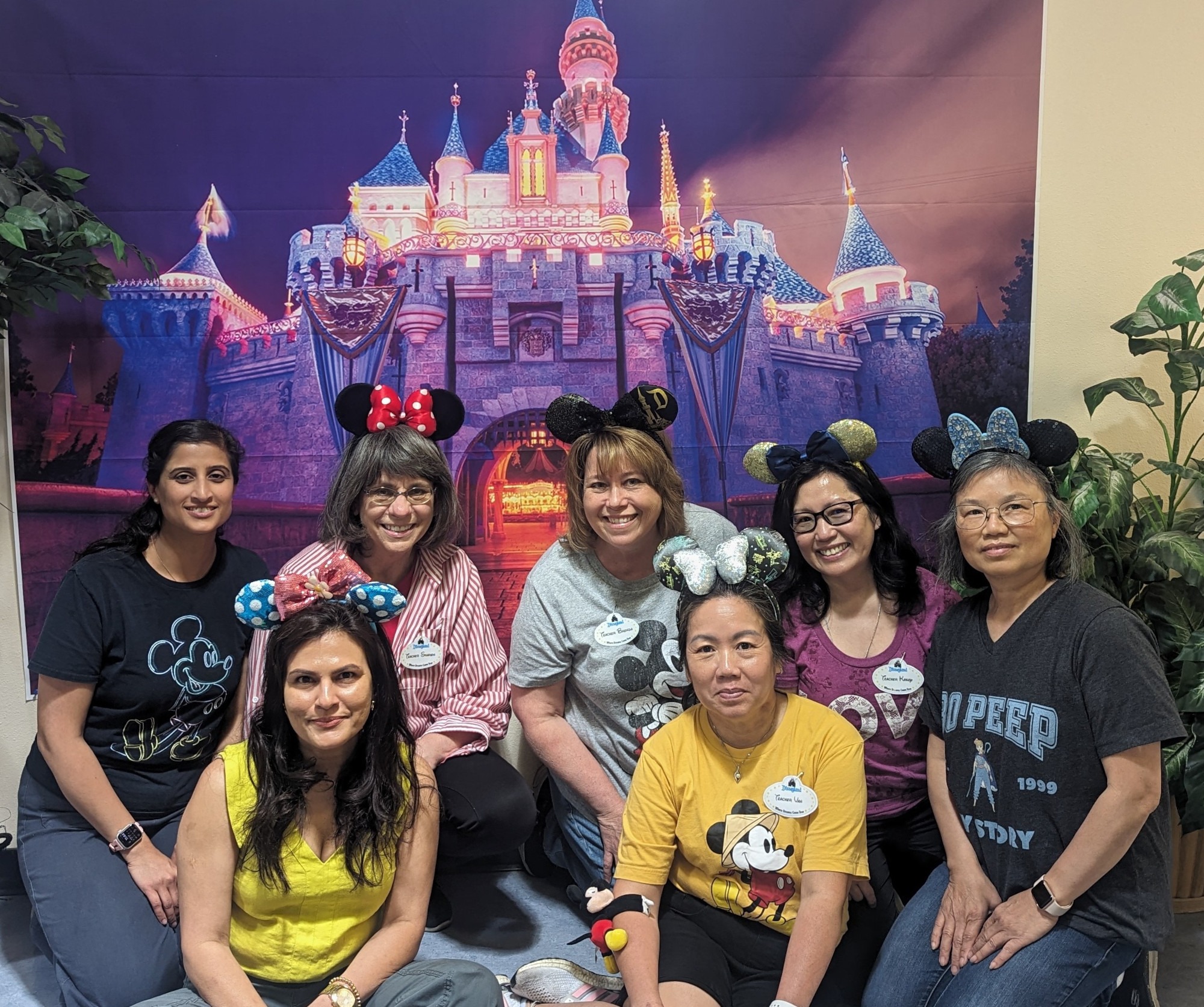 Parent Education staff sitting in front of a picture of Disney Castle